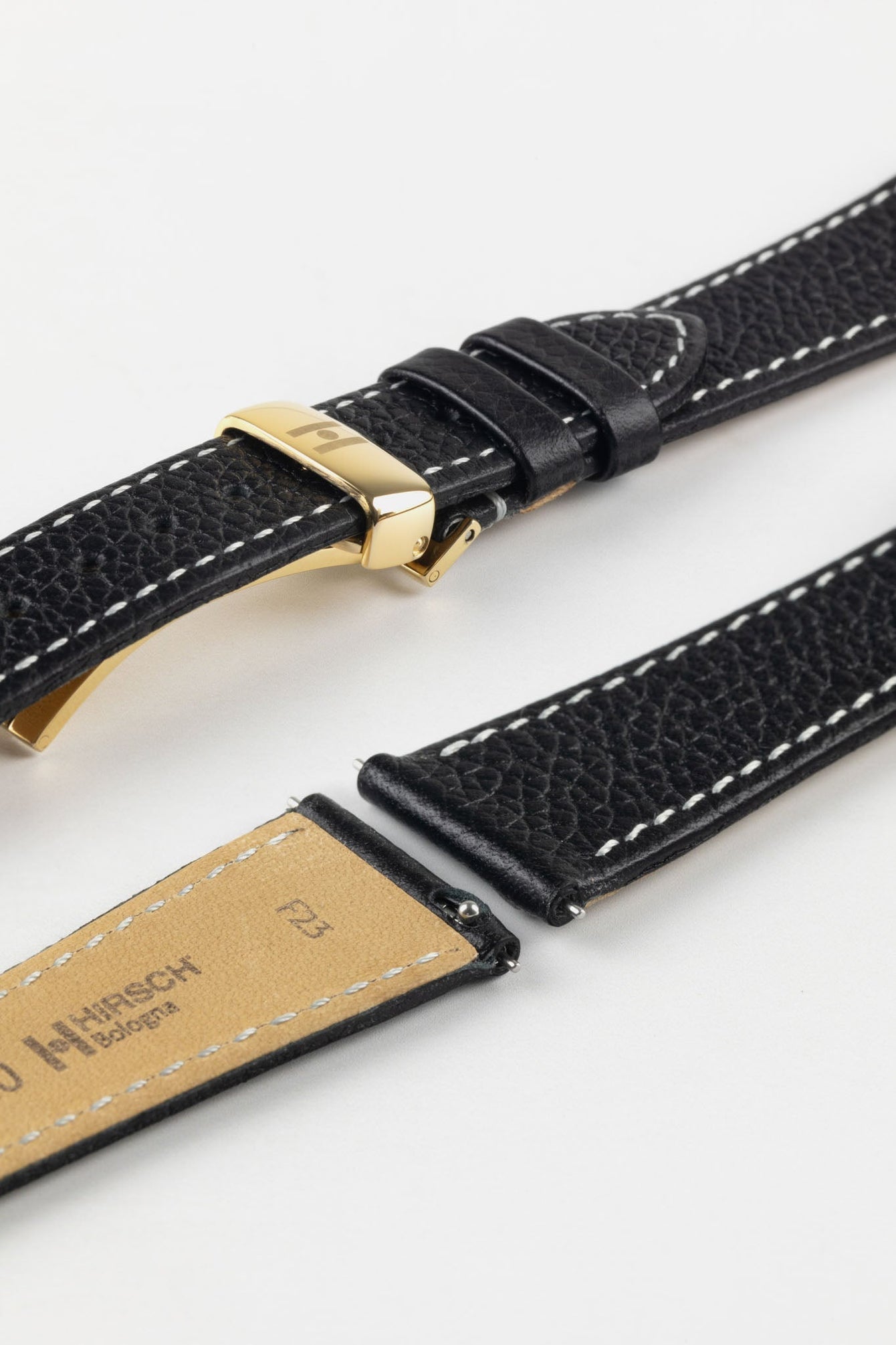 Lug end of Hirsch Bologna showing quick release spring bars and buckled with Hirsch embossed polished gold deployment clasp