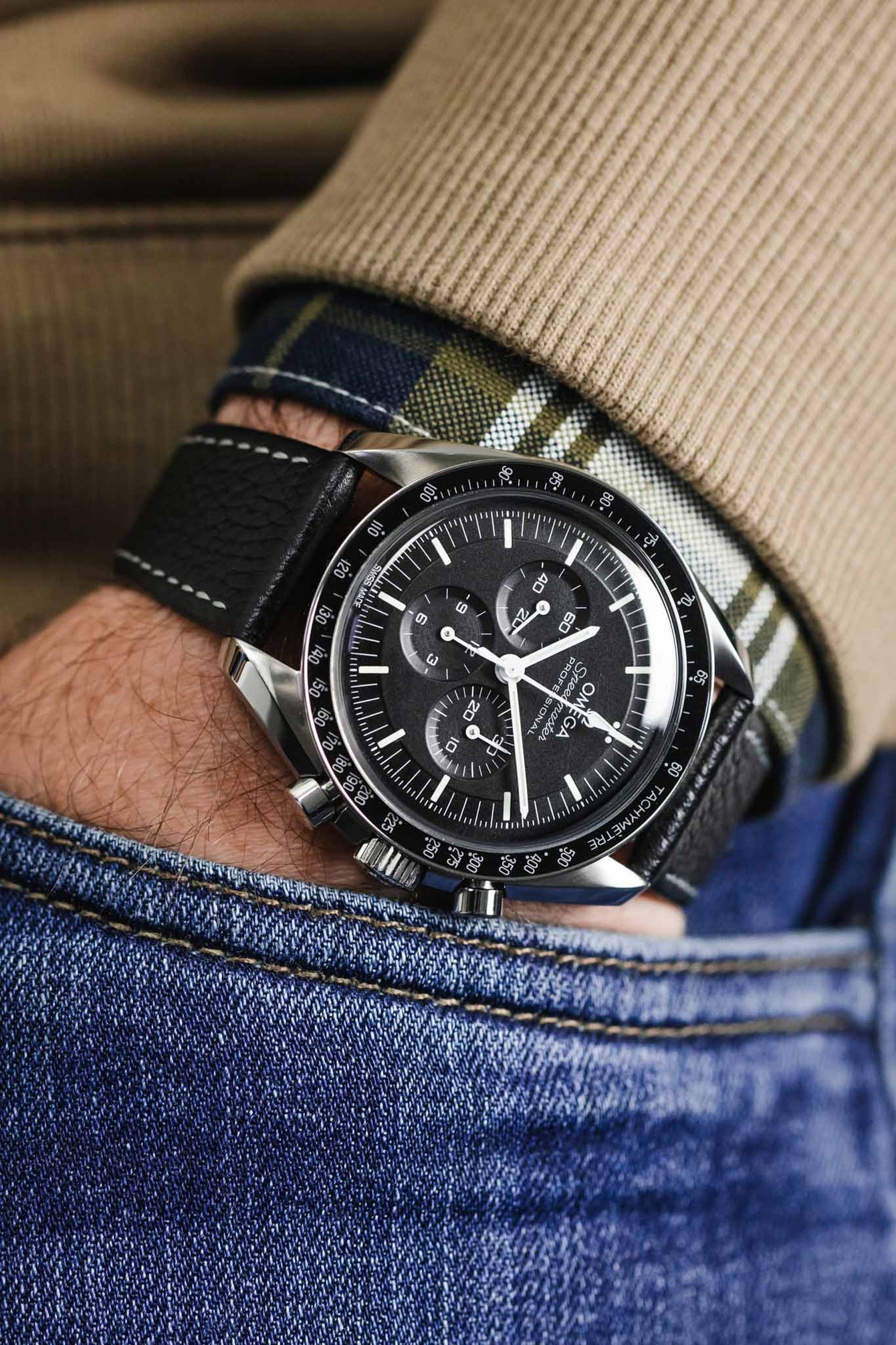 Omega Speedmaster Moonwatch black dial fitted wit black hirsch bologna with white stitching wornon wrist with hand in pocket