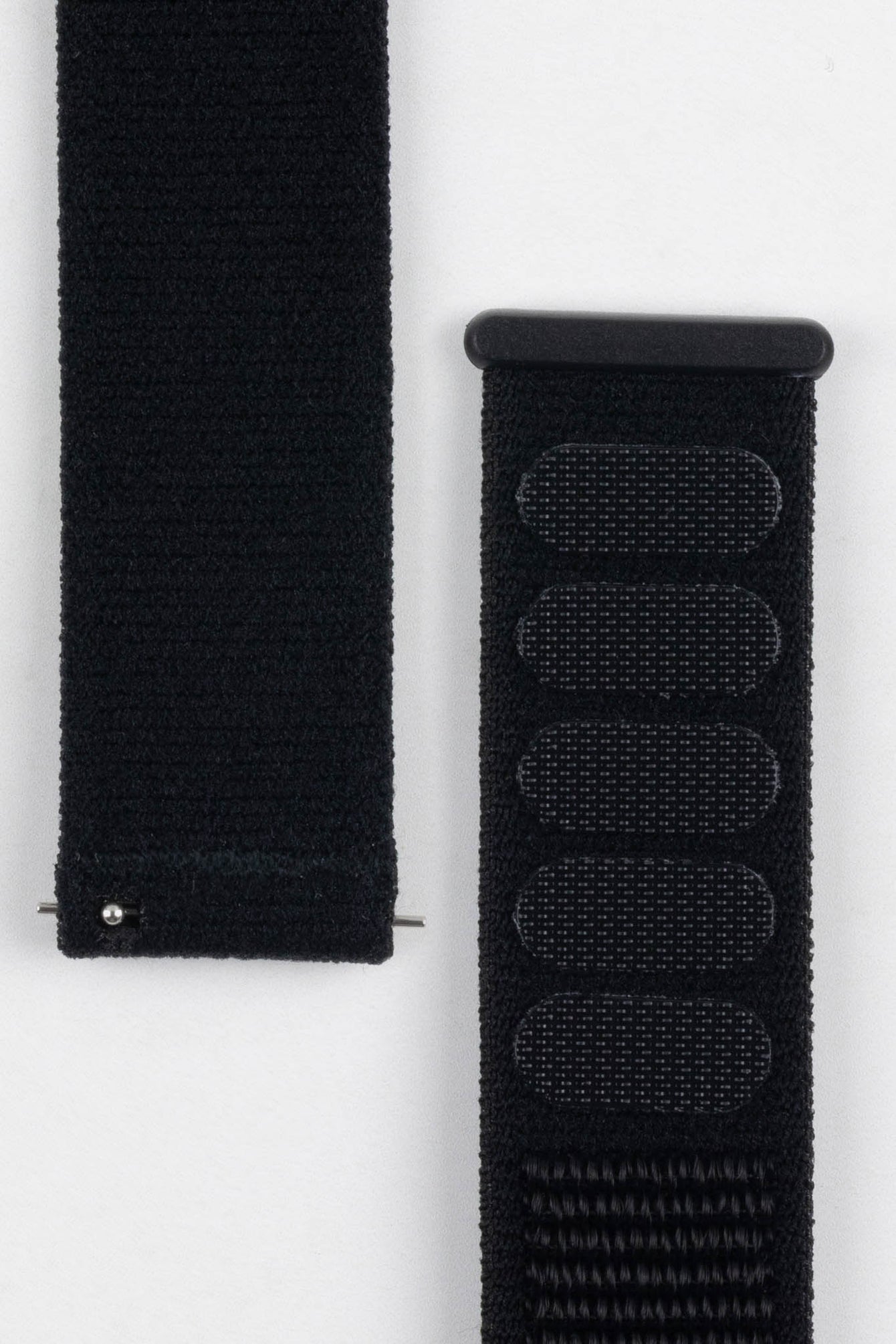 Close-up of a black Hirsch VELCRO watch strap, highlighting the textured nylon and the distinct VELCRO attachment points for adjustment.